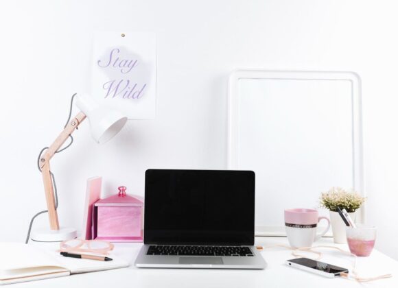 A chic and feminine home office setup with a curved desk, floral decor, and soft lighting.