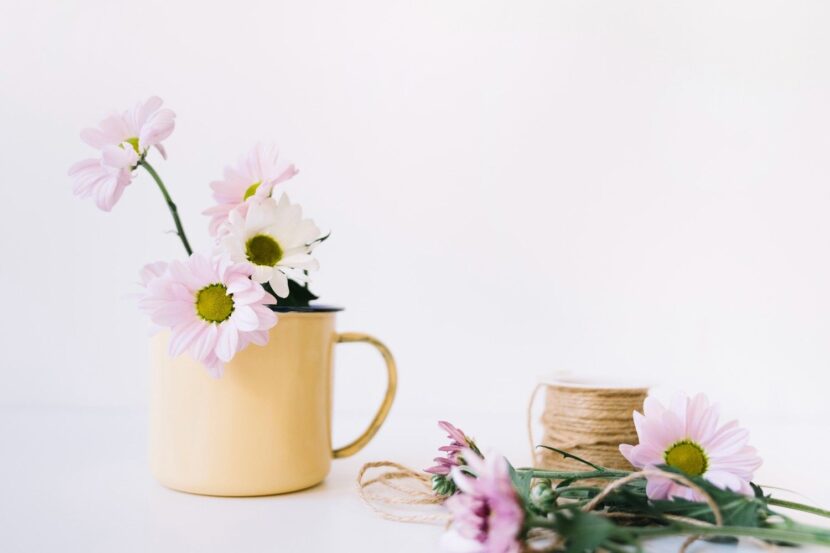 A bright and airy aesthetic featured image for a blog post about March quotes, featuring a vase of fresh tulips and a morning coffee on a sunlit wooden table, representing spring new beginnings.