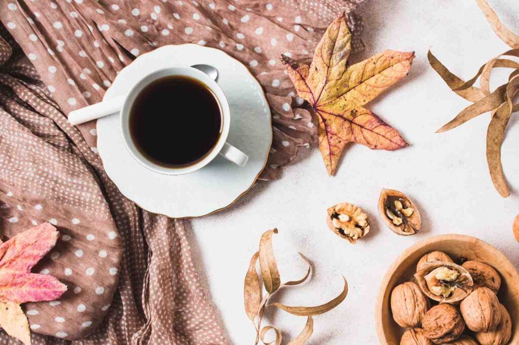 Cup of coffee resting on a porch railing during a crisp fall morning
